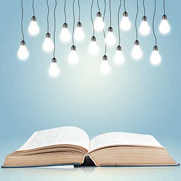 Book with lightbulbs hanging above 